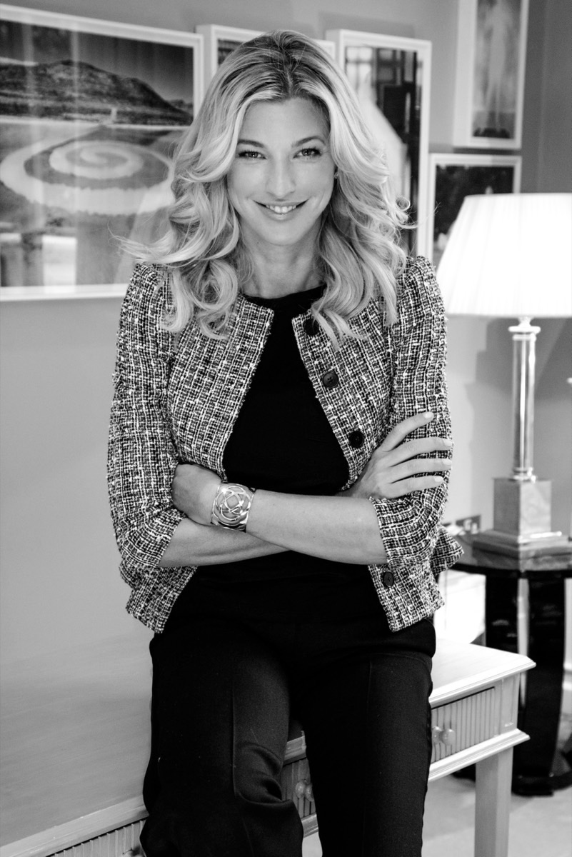 Ritratto in bianco e nero di Nicole Junkermann con giacca di tweed e le braccia incrociate